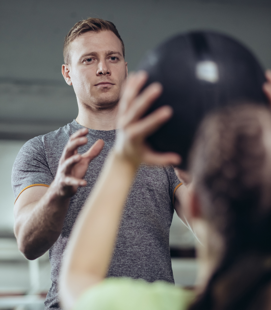 Personal trainer coaching an adult client